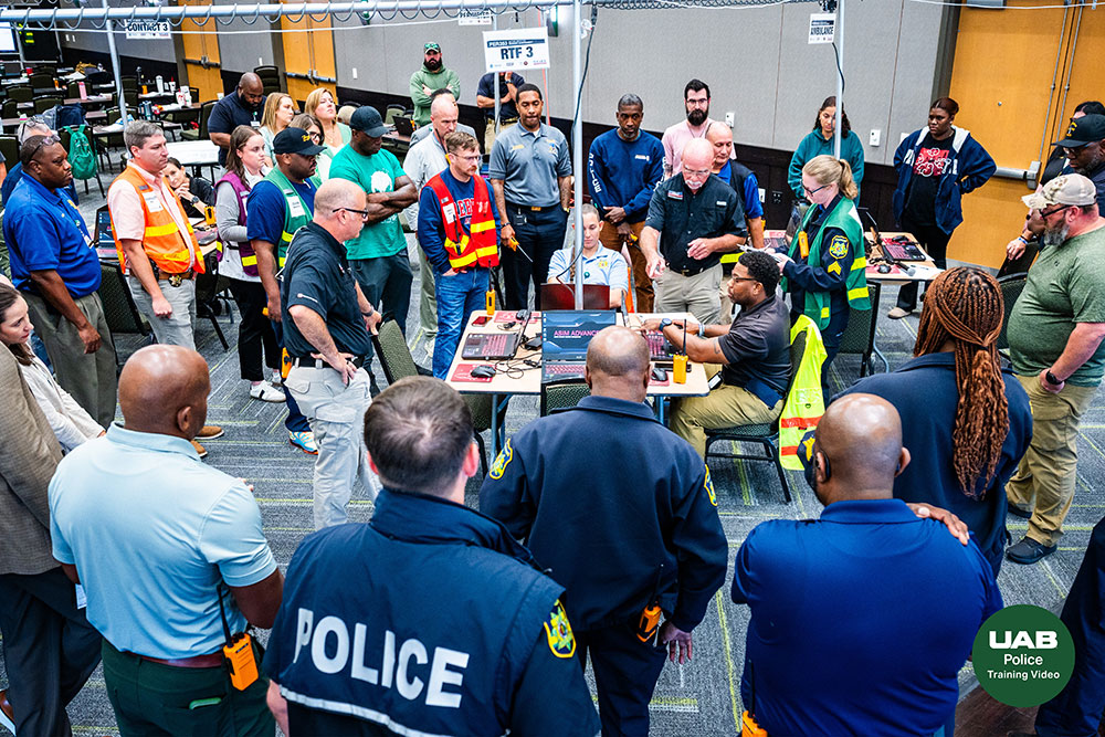 Dozens of participants gather around a central table in an exercise