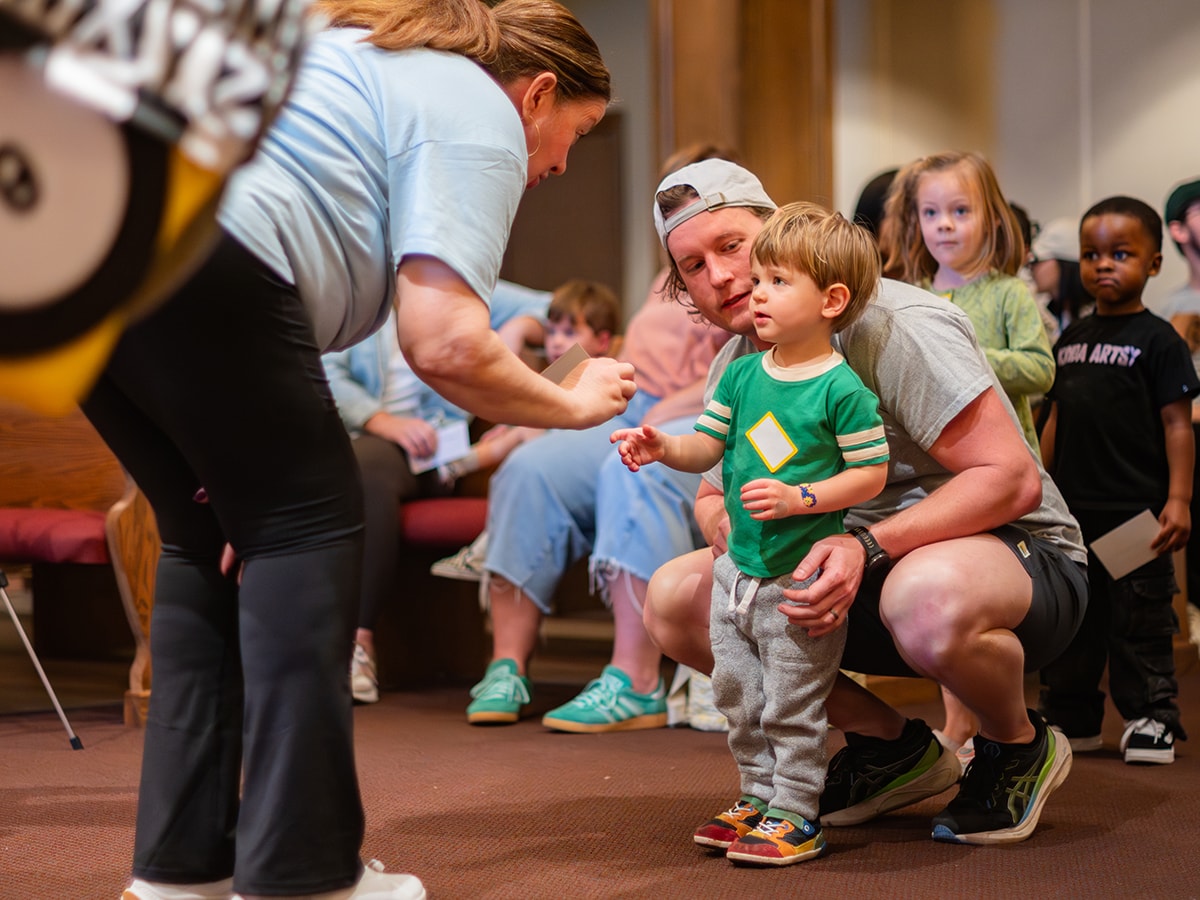 A small boy and his father talk to the announcer at a Vocabby's World event