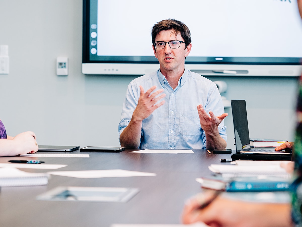 Joshua May, Ph.D., professor in the UAB Department of Philosophy, gestures while teaching in a philosophy class