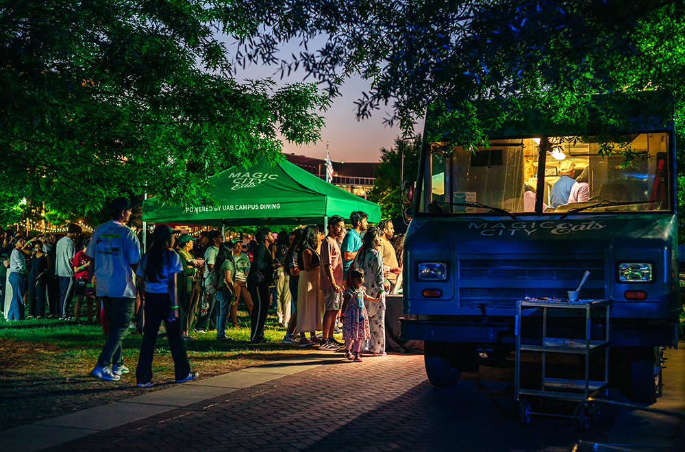 A line of students and other customers at the UAB Crawfish Boil waits to order outside a food truck in the dusk