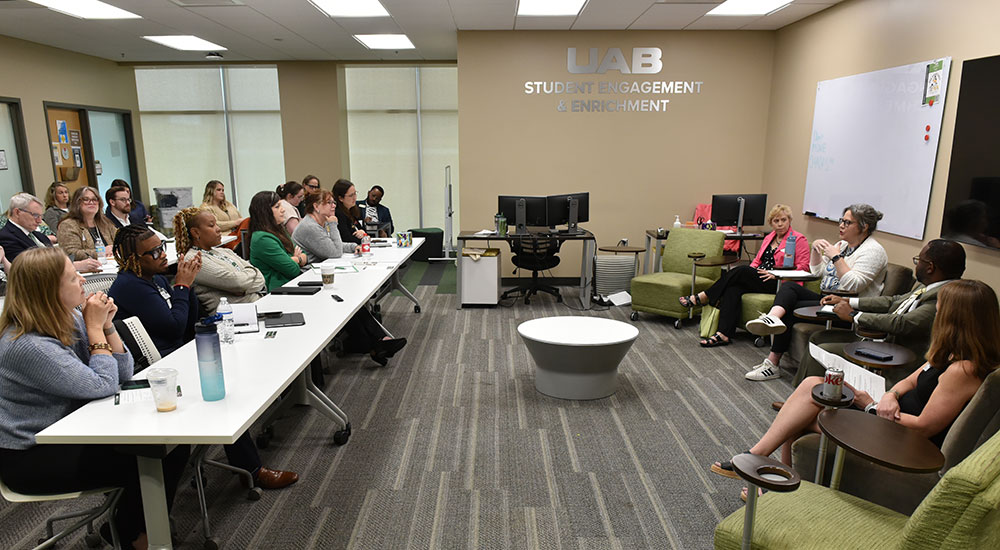More than a dozen attendees listen to a panel of four speakers during a 2026 Student Success Summit breakout session