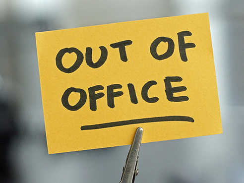 Out of office written on a card at the desk