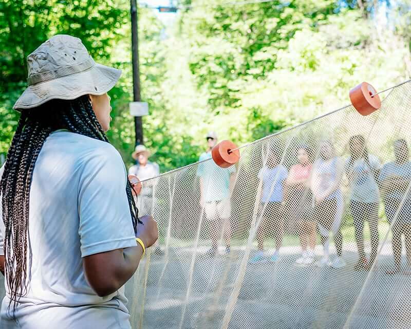 Volunteer coordinator showing volunteers how to use a net.