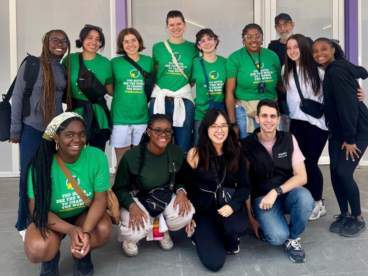 A group of students posing in a modern building hallway.