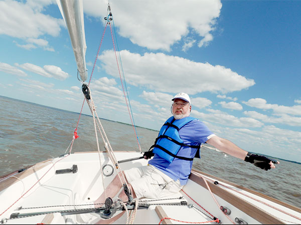 Dr. Crawford sailing at the front of his boat. 