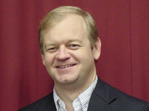 James Tucker, former director of ADAP, wearing a black suit and striped shirt