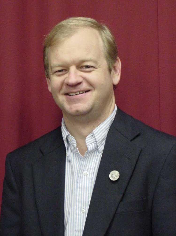 James Tucker, former director of ADAP, wearing a black suit and striped shirt