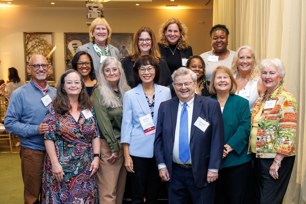 Shannon Houser is in the center, surrounded by 13 friends, family and colleagues from the UAB Department of Health Services Administration.