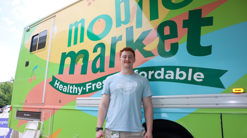 Colvin posed in front of Live HealthSmart Alabama mobile market