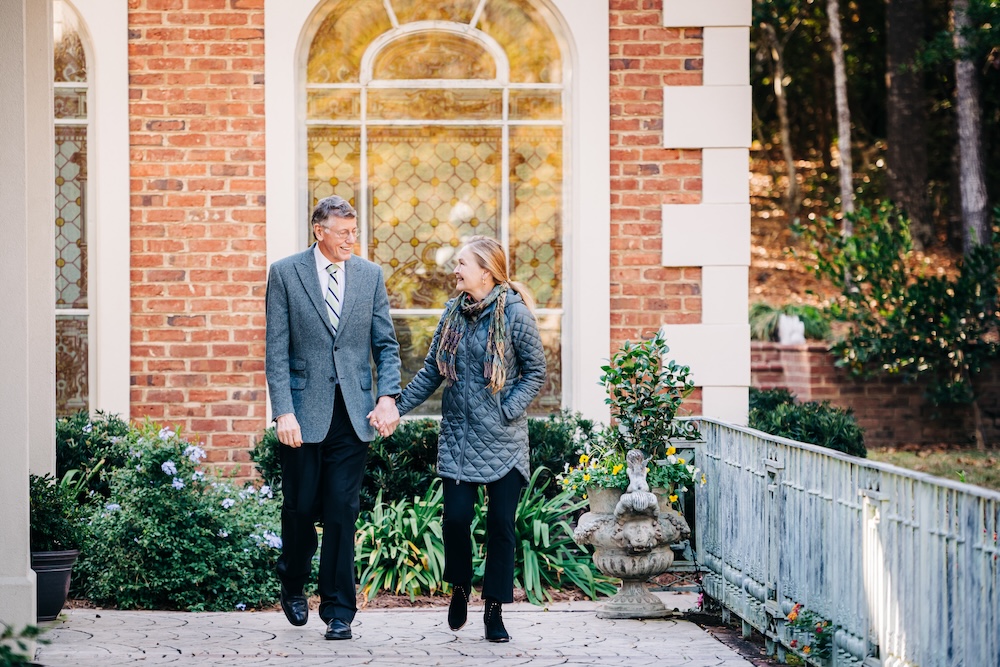 Marnix E. Heersink, M.D., and Mary Heersink walking outside hand-in-hand.