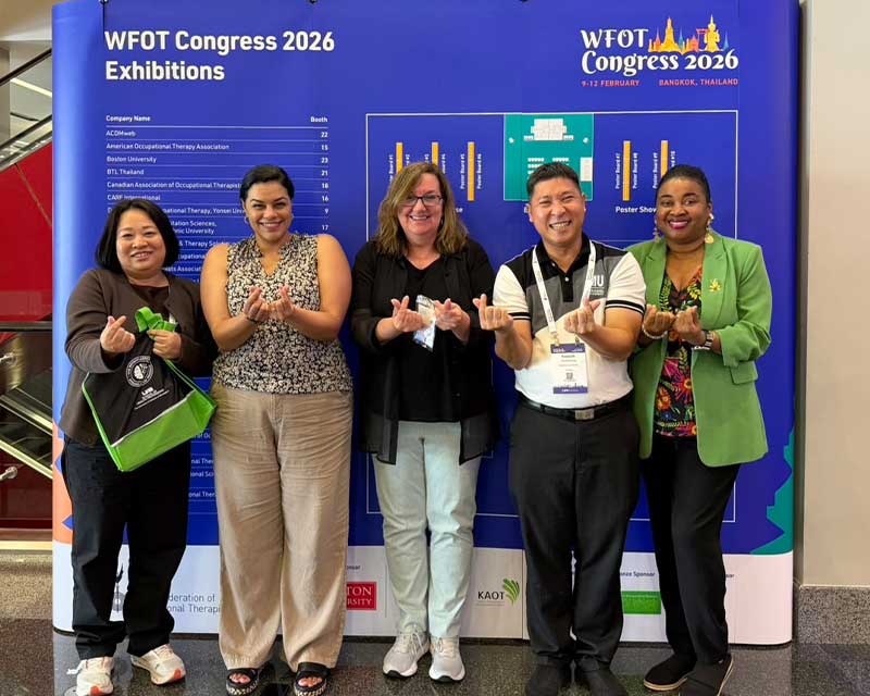UAB faculty and colleagues from Mahidol University share a moment at WFOT 2026 in Bangkok, forming the Thai “little heart” gesture, a sign of affection.