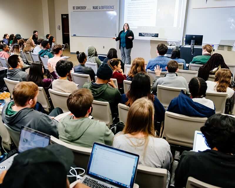 A teacher in front of a classroom of students.