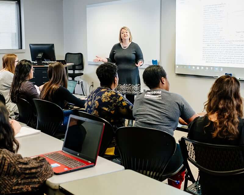 Students listening to a SOPH lecture by a professor. 