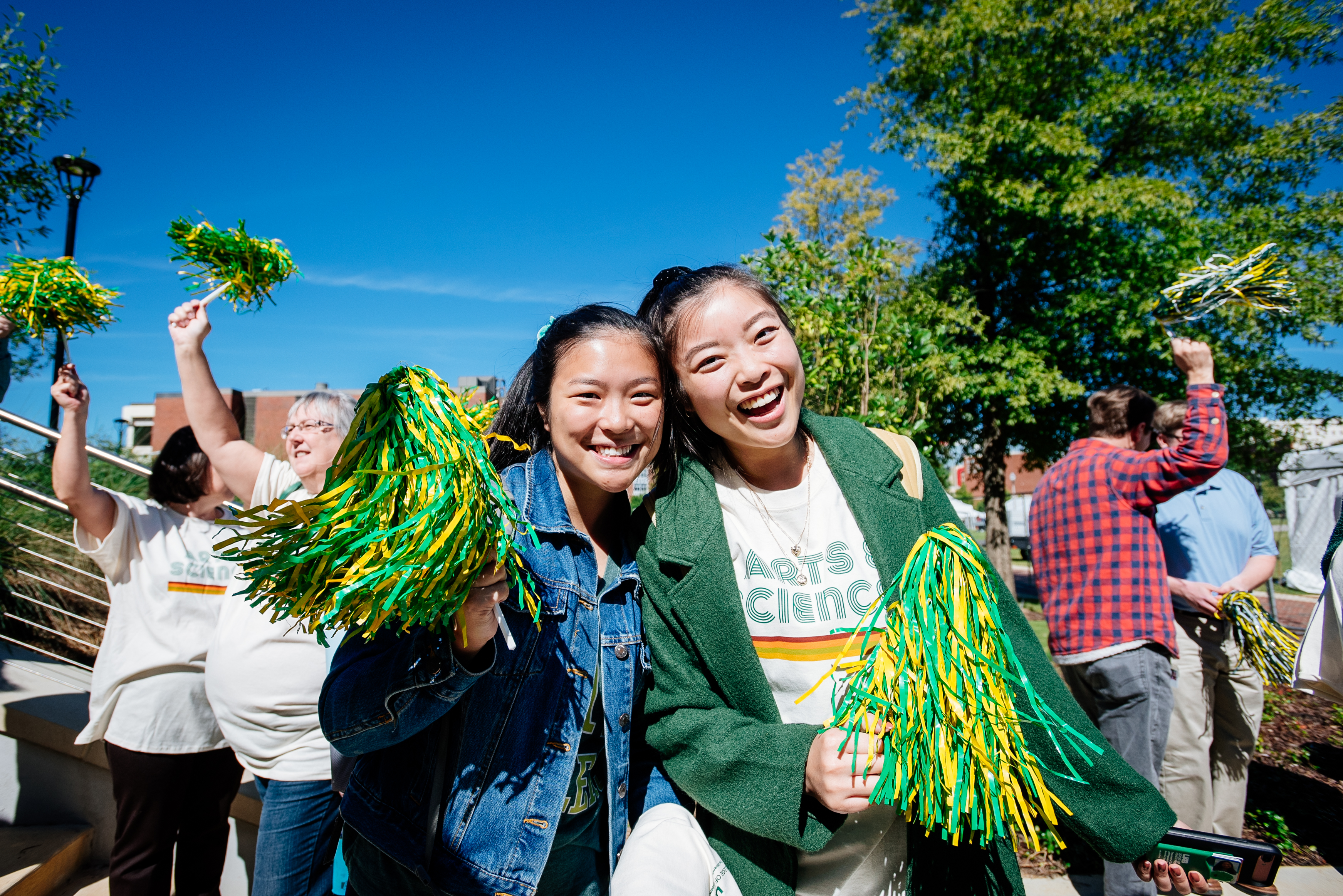 uab students smiling and waving pompoms