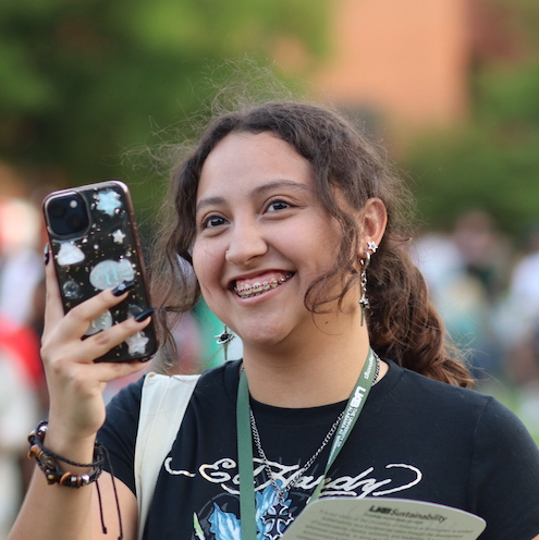 UAB student smiling while using phone at Connect Fest