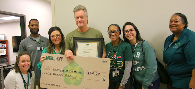 Jeff James receives the Employee of the Month award, surrounded by his team