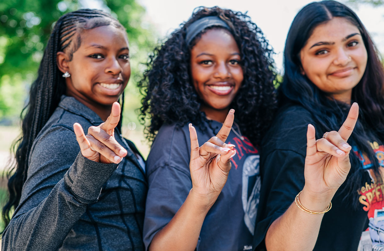 Students posing for the camera with the UAB Blazers hand sign