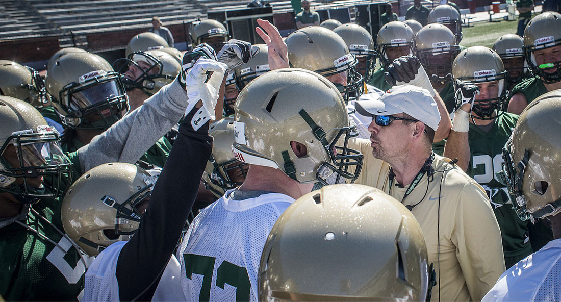 Photo of Coach Bill Clark and football players at practice