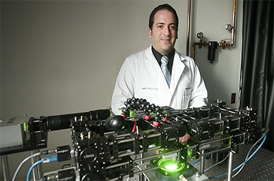 Photo of Massimo Fazio with device that tracks the eye's response to pressure