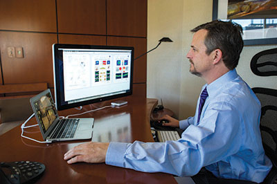 Photo of Christopher Girkin reviewing eye images for early indications of glaucoma via telemedicine.