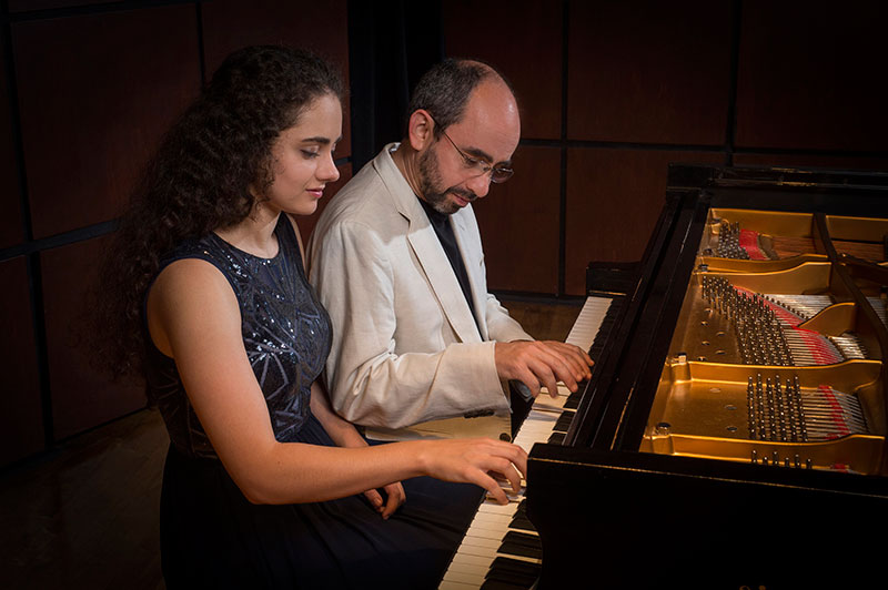 Photo of Sasha and Yakov Kasman performing together on piano