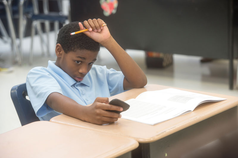 Photo of student looking at calculator.