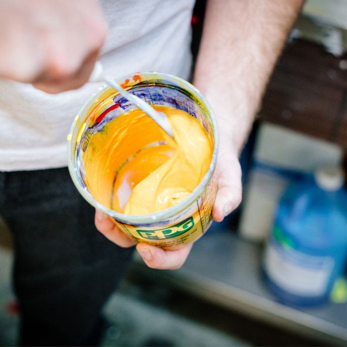 Closeup photo of Brett Forsyth mixing yellow ink