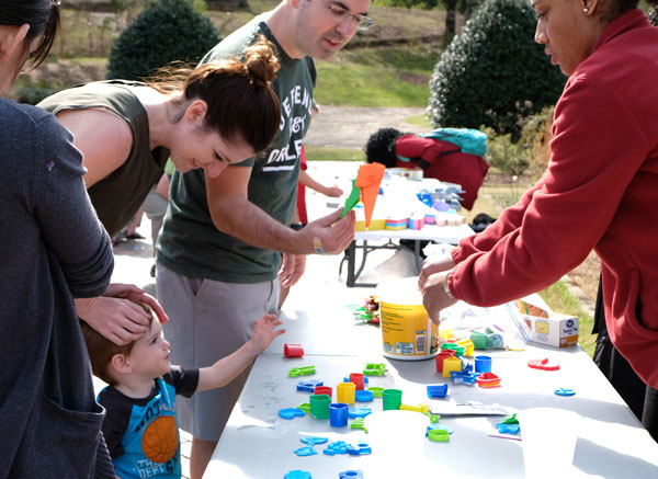 Photo of students working with children and parents at art festival