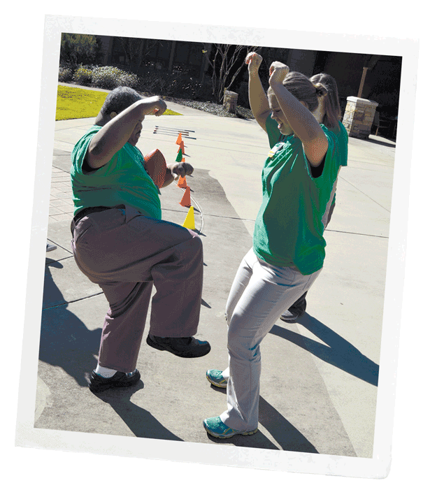 Photo of student cheering on participant through a short obstacle course with cones