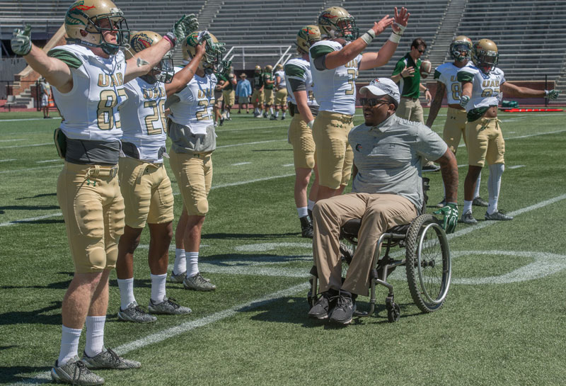 Photo of Timothy Alexander working with players as they do their warmups