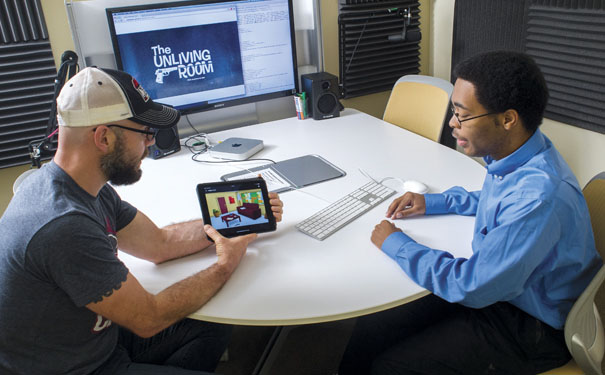 Photo of Scott Thigpen and Jeremy Nelson looking at tablet and desktop computers