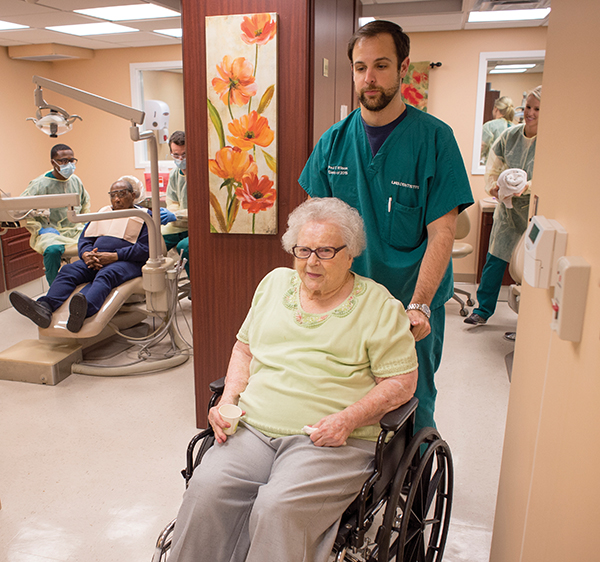 Dental student Paul Wilson escorts a patient from the clinic.