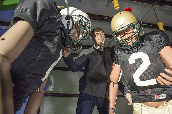 Photo of Blake Feltman setting up crash-test dummies in football gear