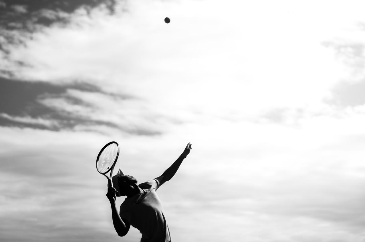 Back, male UAB tennis player is practicing a serve on the court before a Men's tennis game at the Hoover Met Tennis Center.