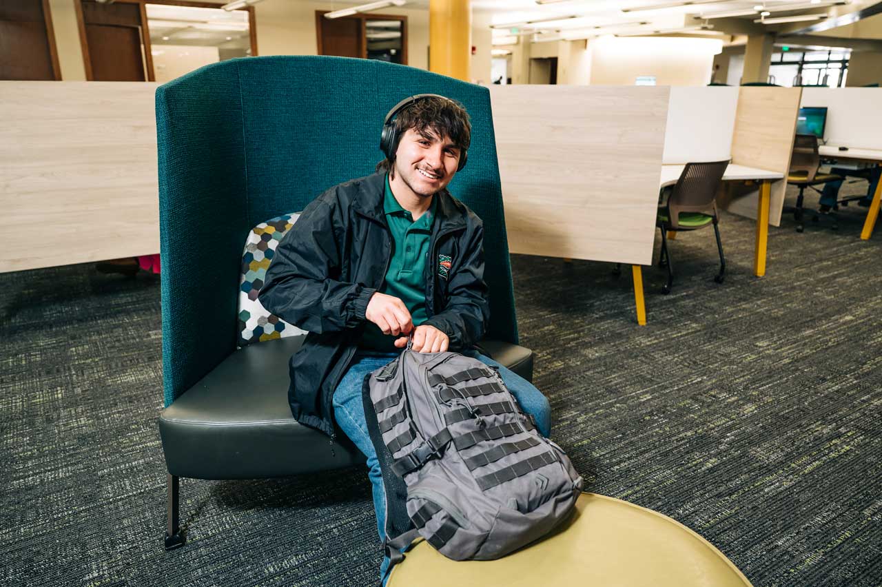 Hollingsworth sits in a lounge chair with his backpack.