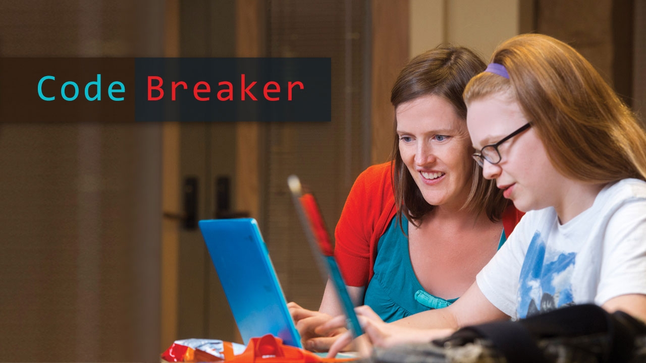 Photo of Lindsay Hannon with Girls Who Code member at computer